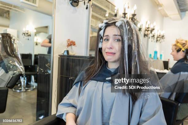 femme jeune nerveuse au salon de coiffure - bad haircut photos et images de collection