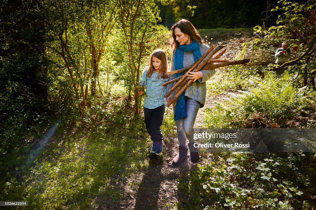 Mother and daughter collecting wood for a camp fire