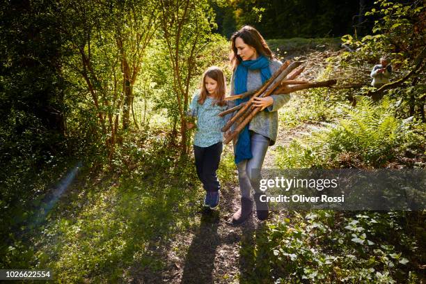 mother and daughter collecting wood for a camp fire - collecting wood stock pictures, royalty-free photos & images