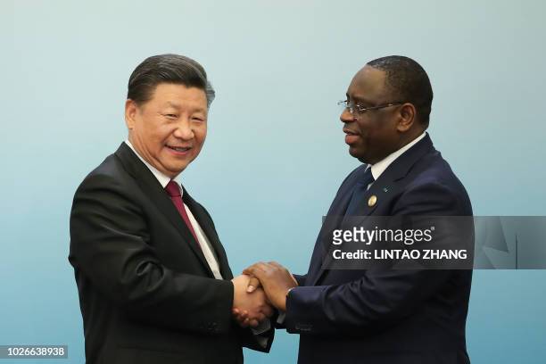 Chinese President Xi Jinping shakes hands with Senegalese President Macky Sall at a joint press conference during the Forum On China-Africa...