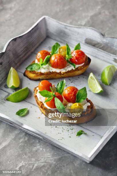 bruschetta mit ricotta, cherry-tomaten und basilikum - bruschetta stock-fotos und bilder