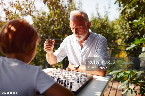 playing chess grandfather grandson - senior playing chess stock pictures, royalty-free photos & images