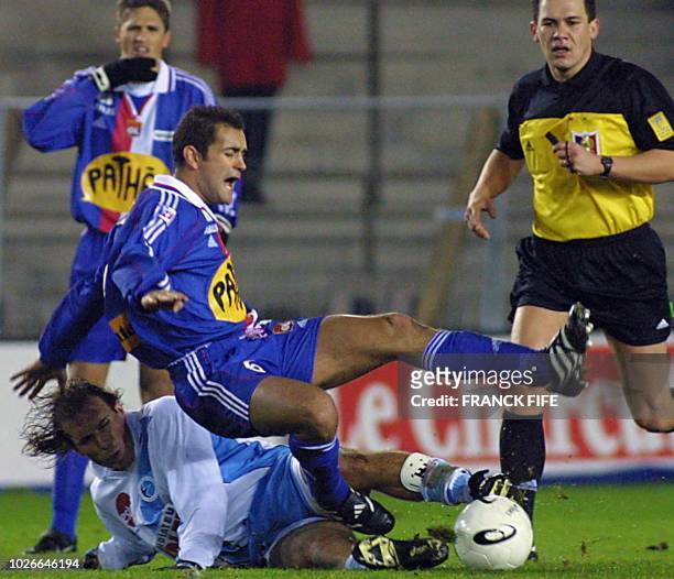 Le Lyonnais Philippe Violeau se fait tacler par le Strasbourgeois Luis Belloso, le 25 novembre 2000 au stade de la Meineau à Strasbourg, lors de la...