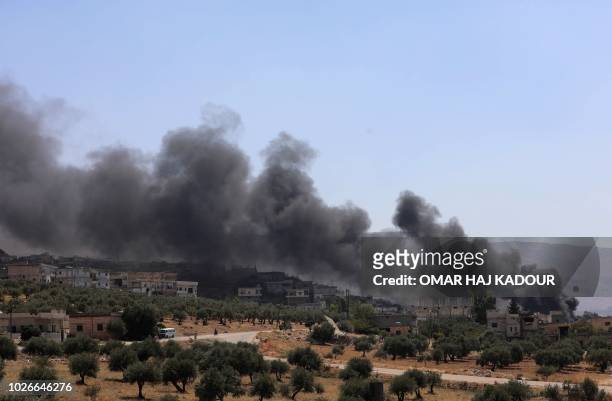 Picture taken on September 4, 2018 shows smoke blowing from buildings on fire that were hit by reported Russian air strikes in the rebel-held town of...
