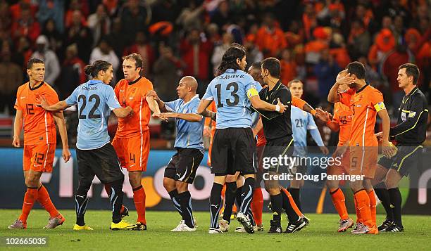 Referee Ravshan Irmatov attempts to break up a melee at the final whistle during the 2010 FIFA World Cup South Africa Semi Final match between...