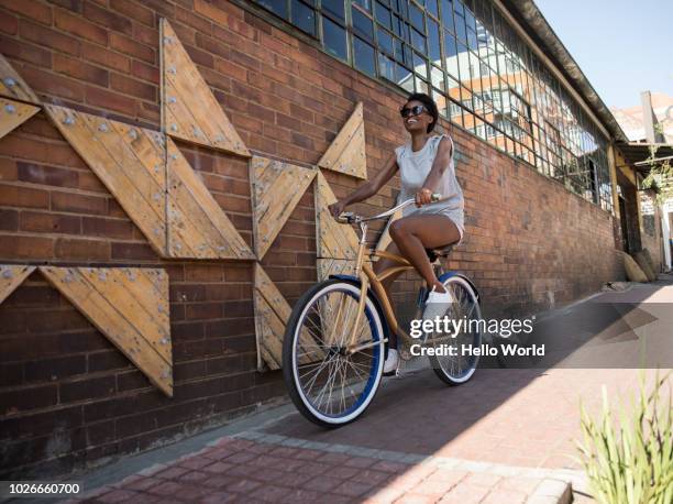 girl riding a bicycle on pavement - johannesburg foto e immagini stock