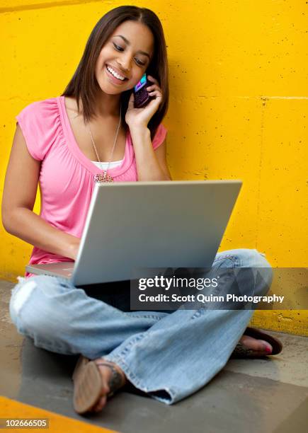 young hispanic female using smartphone - stralende lach stockfoto's en -beelden