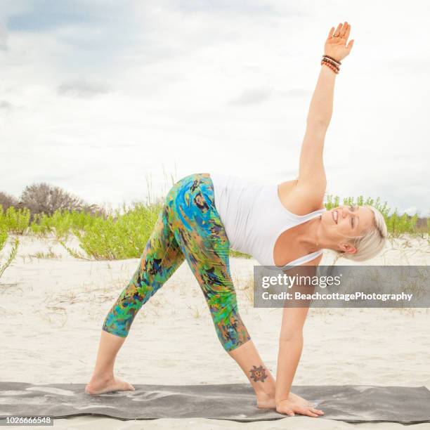 yoga revolved triangle pose on the beach, parivrtta trikonasana - revolved triangle pose stock pictures, royalty-free photos & images