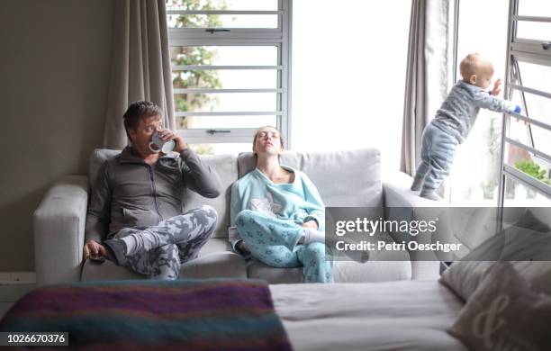 a young family having a lazy day at home. - tired couple stock pictures, royalty-free photos & images