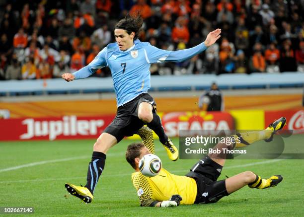 Edinson Cavani of Uruguay jumps over goalkeeper Maarten Stekelenburg of the Netherlands during the 2010 FIFA World Cup South Africa Semi Final match...