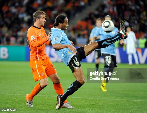 Rafael van der Vaart of the Netherlands watches Alvaro Pereira of Uruguay control the ball during the 2010 FIFA World Cup South Africa Semi Final...