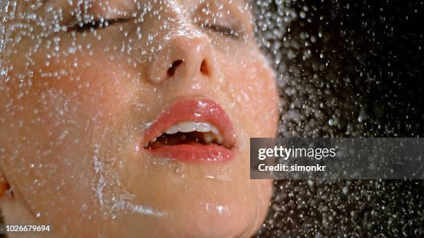 nahaufnahme der frau wird mit wasser bespritzt - damp lips stock-fotos und bilder