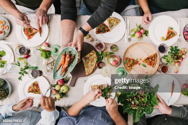 parte de la cosecha de amigos disfrutando de una cena juntos en invernadero - vegan food fotografías e imágenes de stock