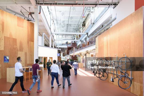 Employees walk past a wall bike rack at the new Facebook Inc. Frank Gehry-designed MPK 21 office building in Menlo Park, California, U.S., on...