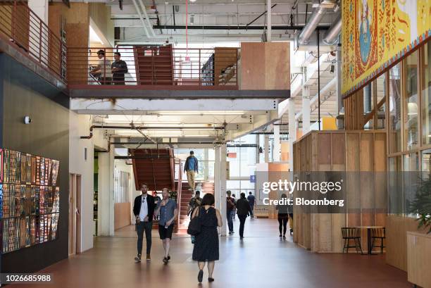Employees walk through the main corridor at the new Facebook Inc. Frank Gehry-designed MPK 21 office building in Menlo Park, California, U.S., on...