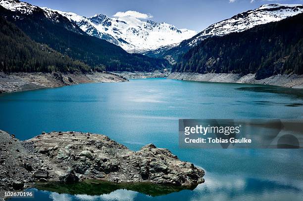 lake in the swiss alps and snow - tobias gaulke stock-fotos und bilder