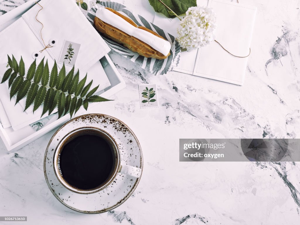 The top view of marble desk with cup of coffee and book