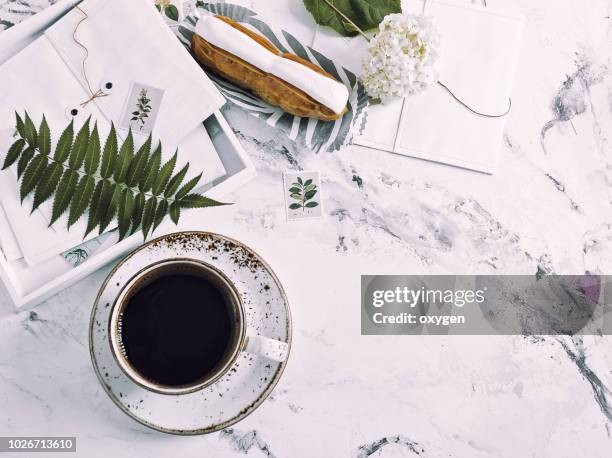 the top view of marble desk with cup of coffee and book - flat lay stock pictures, royalty-free photos & images