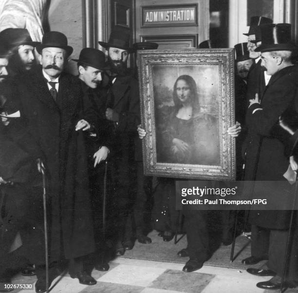 Officials gather around Leonardo da Vinci's 'Mona Lisa' upon its return to Paris, 4th January 1914. It was stolen from the Musee du Louvre by...