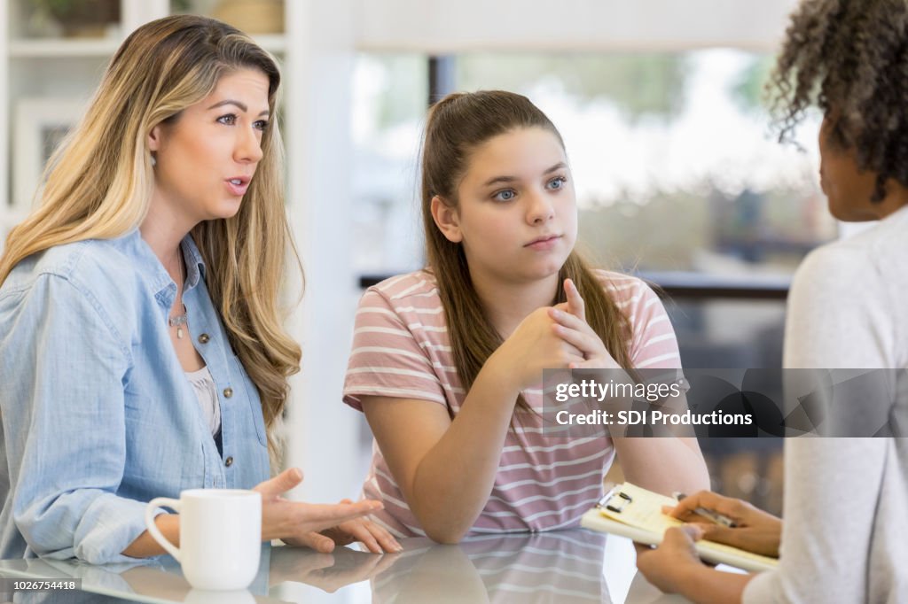 Teenage girl and her mom talk with school counselor