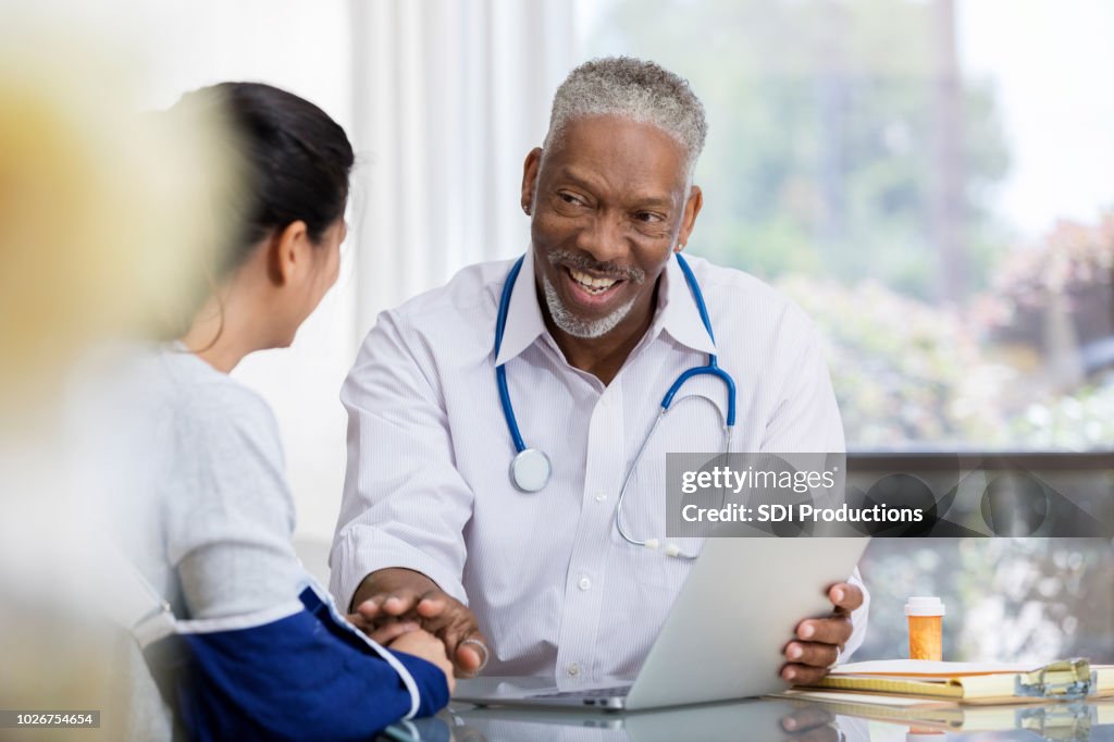 Caring male doctor talks with female patient
