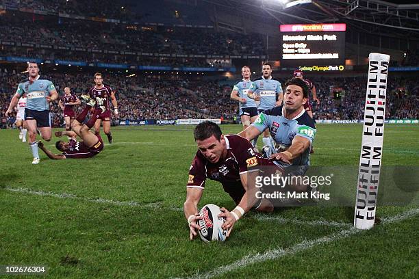 Darius Boyd of the Maroons beats the tackle of Trent Barrett of the Blues to score in the corner during game three of the ARL State of Origin series...