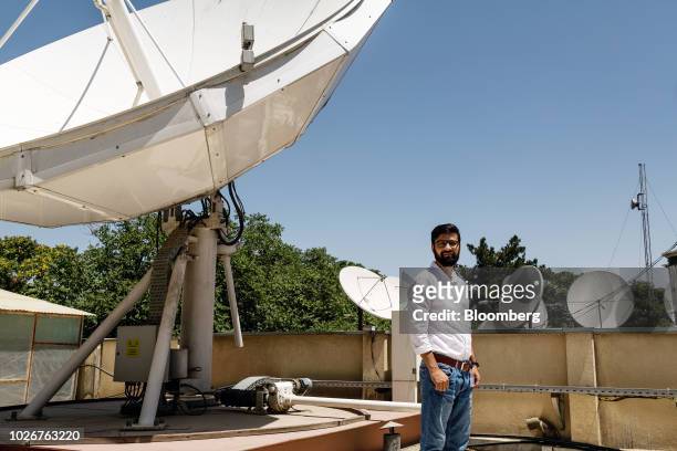 Seayer Ahadzada, commercial director at Alef Technology, stands for a photograph next to a parabolic antennae on the roof of the company's office in...