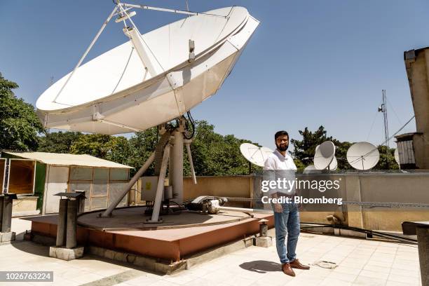 Seayer Ahadzada, commercial director at Alef Technology, stands for a photograph next to a parabolic antennae on the roof of the company's office in...