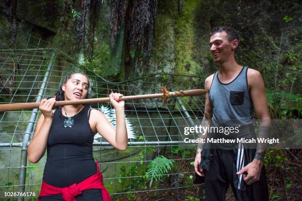 travelers visit some of the oldest maori rock paintings in new zealand as a local woman shows some traditional culture. - maori warrior stock pictures, royalty-free photos & images