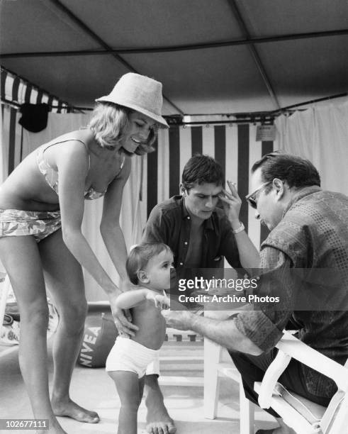 French actor Alain Delon with his wife Nathalie and their son Anthony on the beach at Monte Carlo, 15th August 1965.