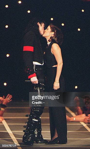 Pop star Michael Jackson and his wife Lisa Marie Presley kiss on the stage of Radio City Music Hall 8 September 1994 in New York where they attended...