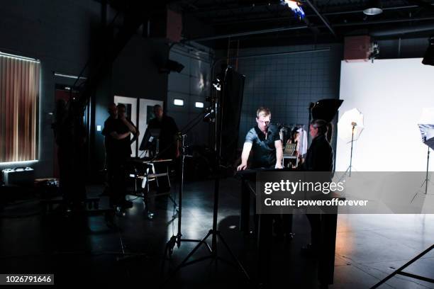 gente trabajando detrás de las escenas mientras que película en un set de película - film industry photos fotografías e imágenes de stock