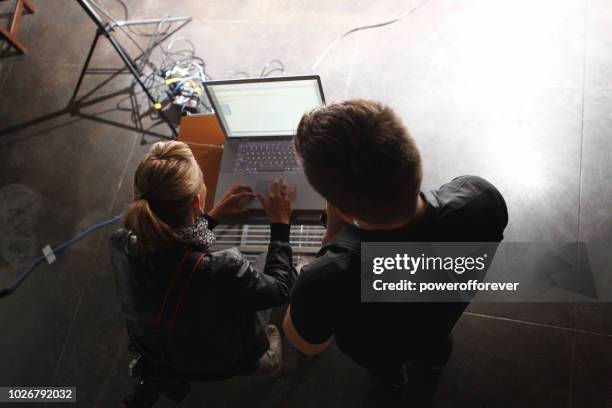 people working on a laptop behind the scenes on a film set - movie crew stock pictures, royalty-free photos & images