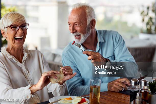 senior couple having breakfast in restaurant - senior adult eating stock pictures, royalty-free photos & images