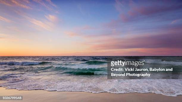 beautiful pastel-colored sunrise at jones beach, long island - wasserrand stock-fotos und bilder