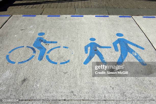 bicycle and pedestrian crossing stencilled on a concrete road - cycling streets stock pictures, royalty-free photos & images