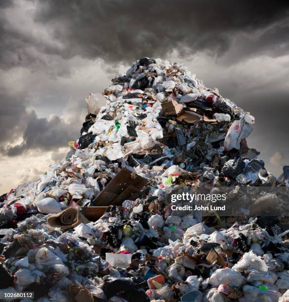 a mountain of garbage looms above - garbage stockfoto's en -beelden