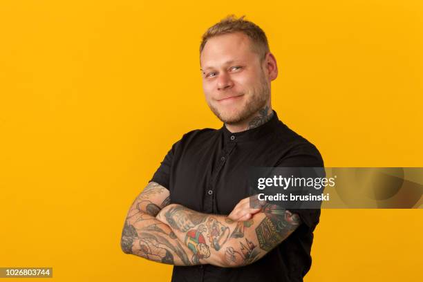 studio porträtt av en frisör på gul bakgrund - man tatoo bildbanksfoton och bilder