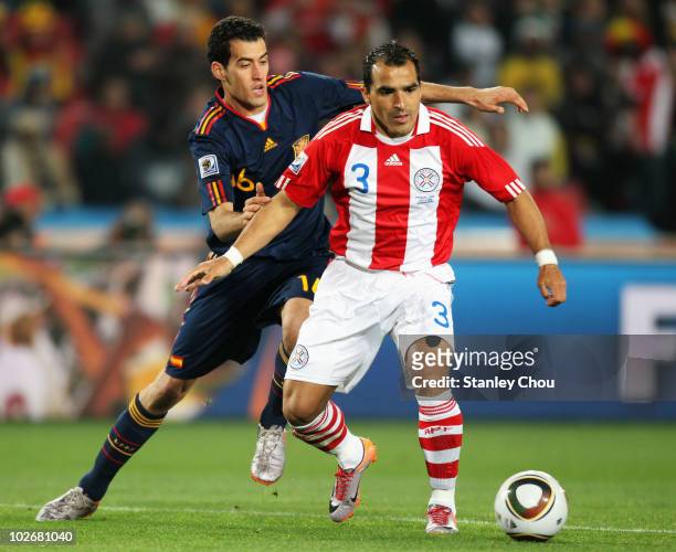 Sergio Busquets of Spain and Claudio Morel of Paraguay tussle for the ball during the 2010 FIFA World Cup South Africa Quarter Final match between...