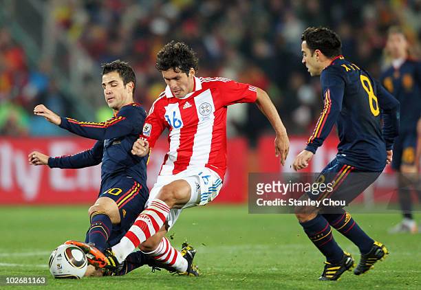 Cristian Riveros of Paraguay is tackled by Francesc Fabregas of Spain during the 2010 FIFA World Cup South Africa Quarter Final match between...