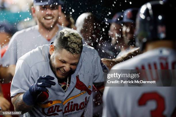 Yadier Molina of the St. Louis Cardinals celebrates with his teammates in the dugout after hitting a grand slam in the ninth inning against the...