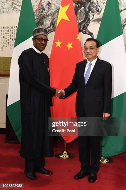 Nigerian President Muhammadu Buhari shakes hands with Chinese Premier Li Keqiang before their meeting at the Diaoyutai State Guesthouse in Beijing,...