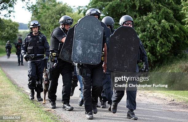 Armed police escort a man along a track near Wagtail Farm in the village of Rothbury as the search for armed fugitive Raoul Moat goes on in the...