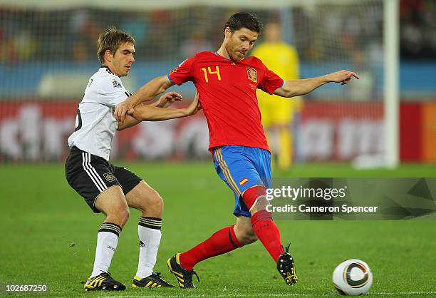 Philipp Lahm of Germany challenges Xabi Alonso of Spain during the 2010 FIFA World Cup South Africa Semi Final match between Germany and Spain at...