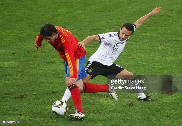 Joan Capdevila of Spain is challenged by Piotr Trochowski of Germany during the 2010 FIFA World Cup South Africa Semi Final match between Germany and...