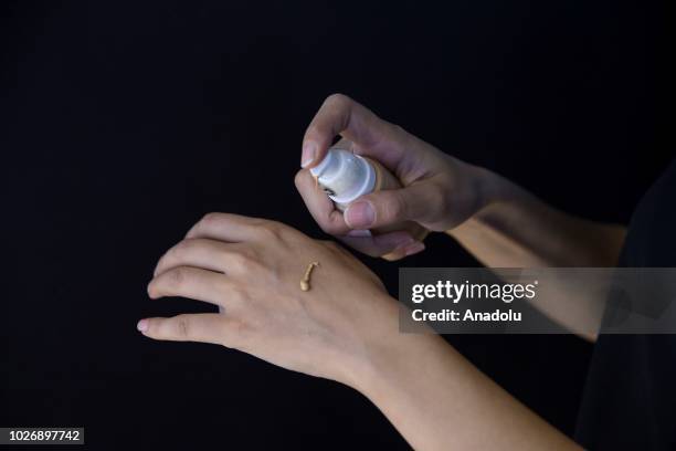 Photo shows the close-up hands of a woman applying concealer foundation cream at a make-up and cosmetic products shop in Ankara, Turkey on September...