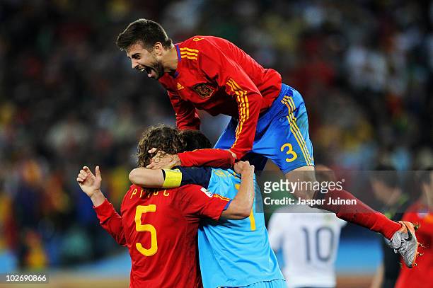 Carles Puyol of Spain celebrates with team mates Iker Casillas and Gerard Pique after victory and progress to the final during the 2010 FIFA World...
