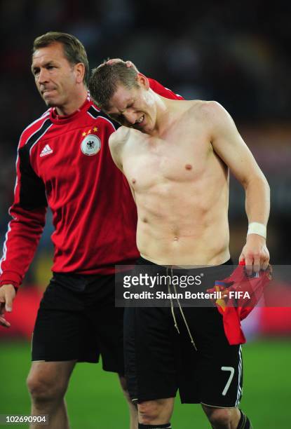 Germany goalkeeping coach Andreas Koepke comforts Bastian Schweinsteiger of Germany after the 2010 FIFA World Cup South Africa Semi Final match...