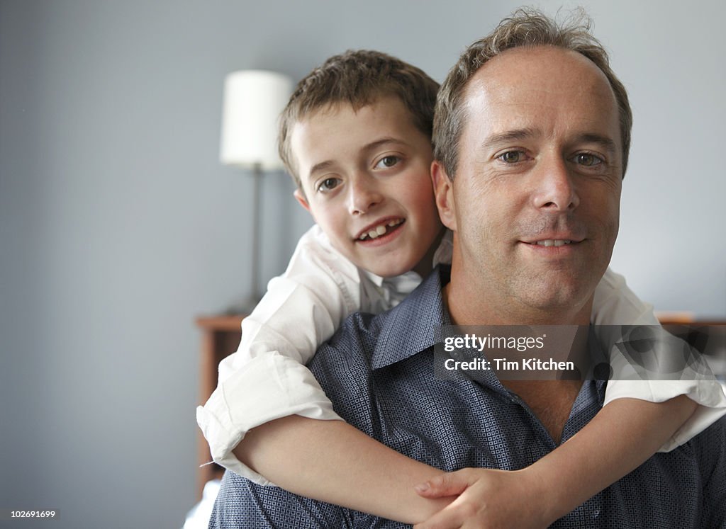 Boy on father's back, hugging, portrait