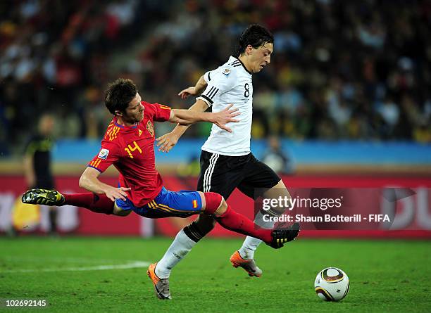 Mesut Oezil of Germany in action against Xabi Alonso of Spain during the 2010 FIFA World Cup South Africa Semi Final match between Germany and Spain...